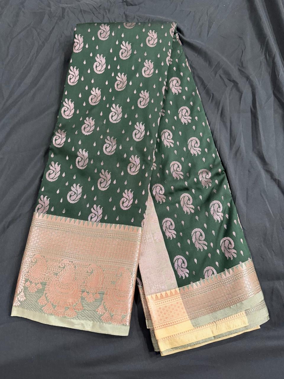 Forest green saree with paisley and butta motifs and ornate gold border, body detail view
