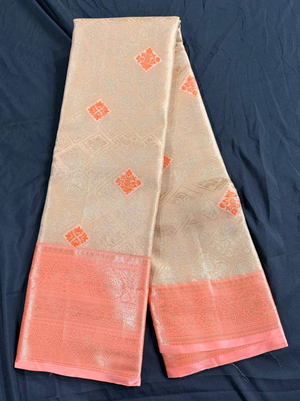 Cream Kanchipuram silk saree with scattered geometric butta motifs in coral-orange and ornate coral-orange border, body detail view