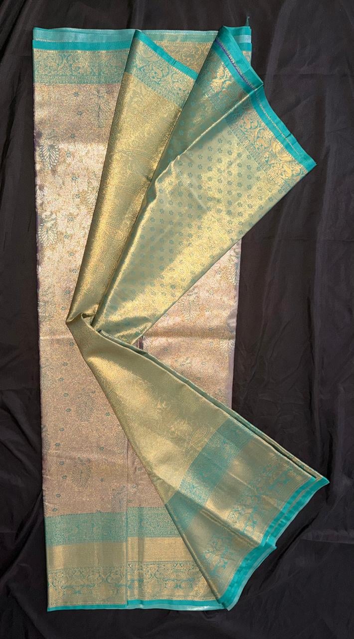 Antique gold Kanchipuram silk saree with scattered floral and butta motifs, wide ornate teal-and-gold border, draped product view