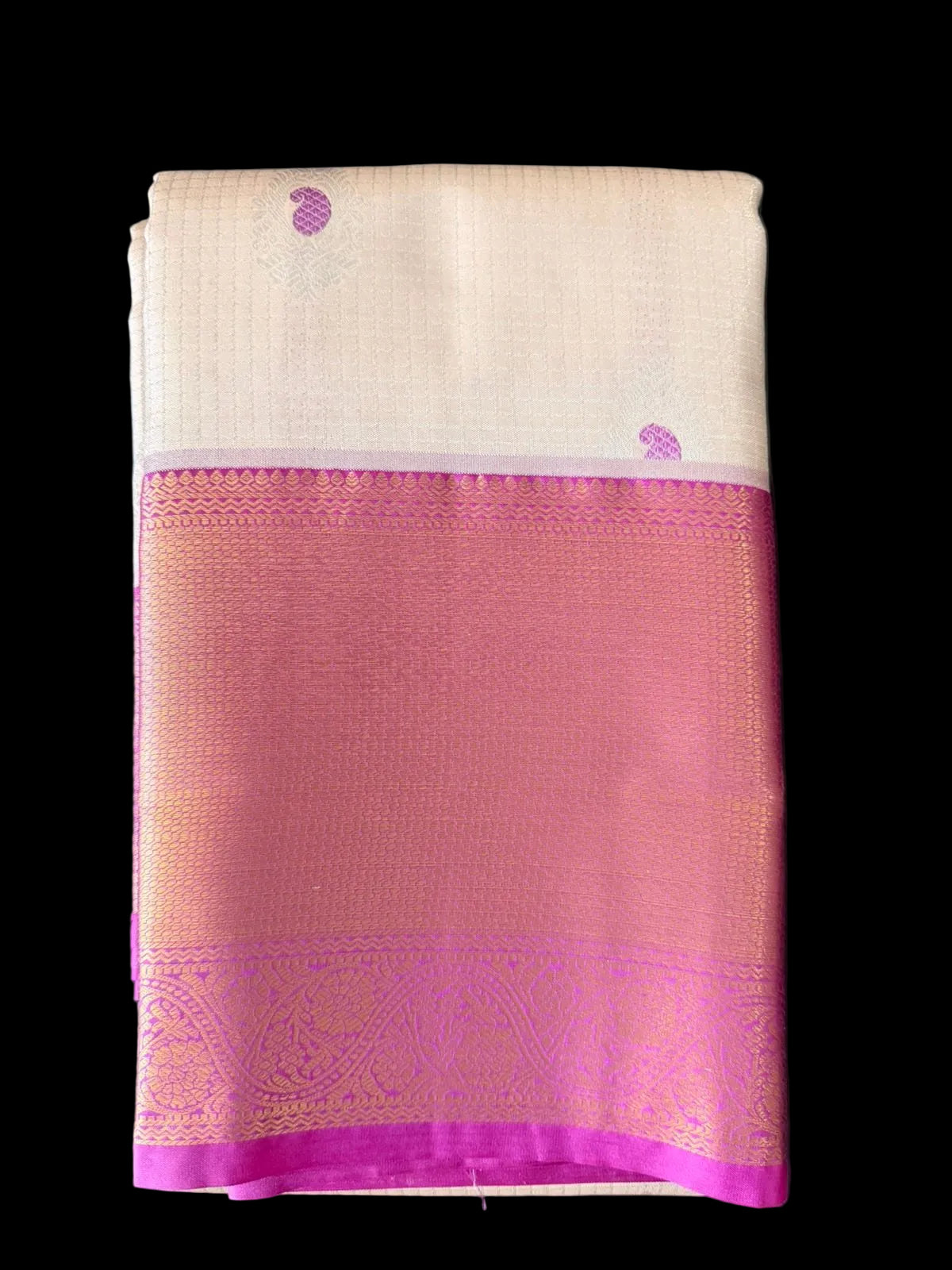 Cream ivory Kanchipuram silk saree with scattered butta motifs and pink-gold woven border, folded detail view