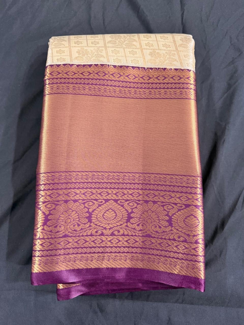 Cream Kanchipuram silk saree with butta motifs and ornate purple-gold border, pallu detail view