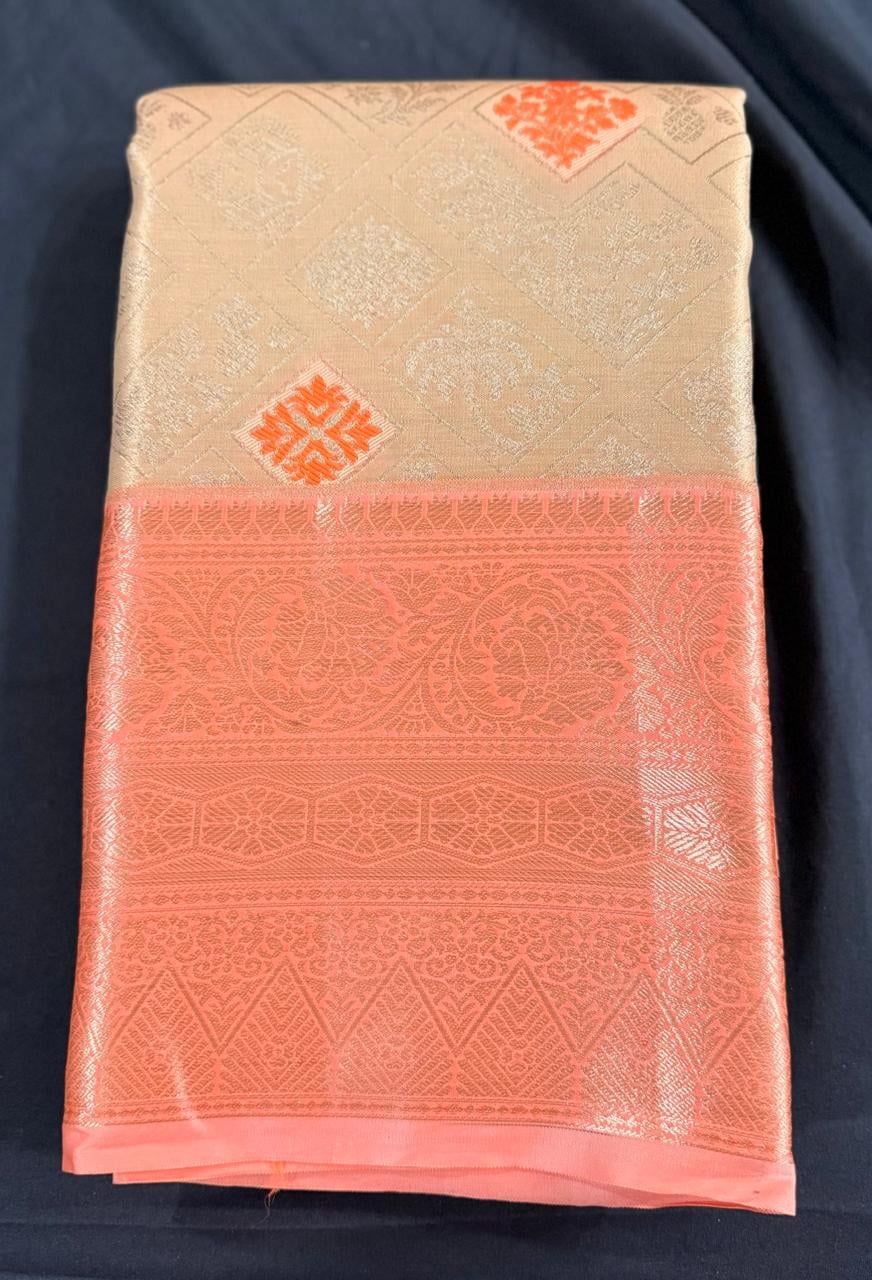 Cream Kanchipuram silk saree with scattered geometric butta motifs in coral-orange and ornate coral-orange border, folded detail view