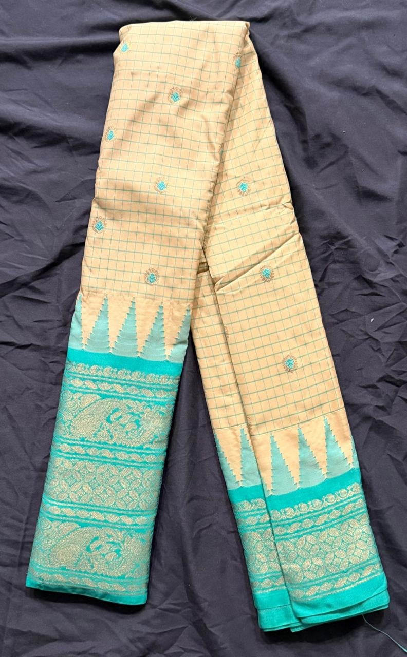 Teal green Kanchipuram silk saree with gold paisley and temple motifs, teal-gold border, folded detail view