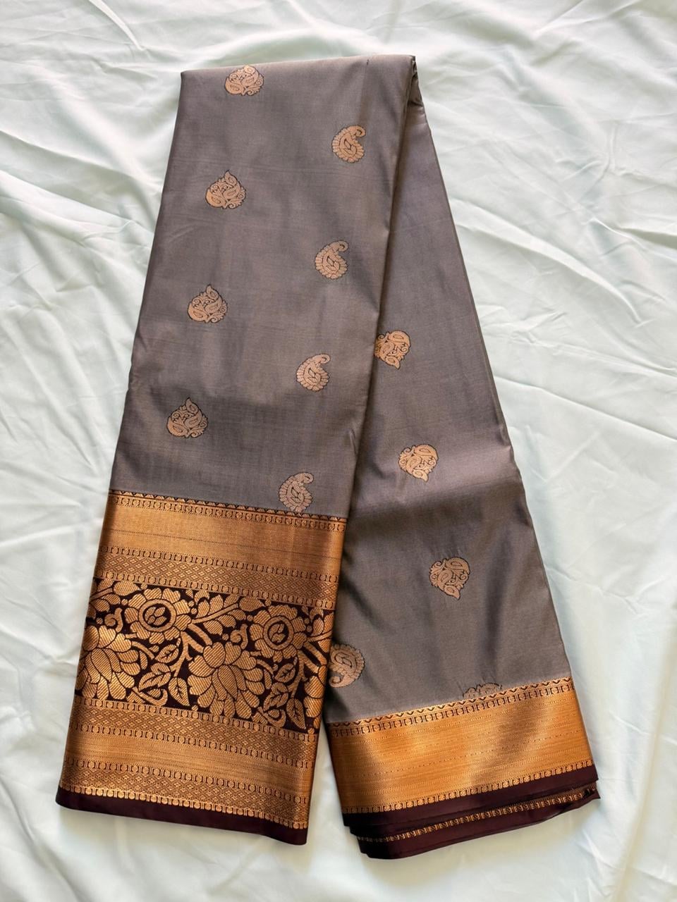 Warm taupe-brown Kanchipuram silk saree with ornate gold and dark brown scrollwork, pallu detail view