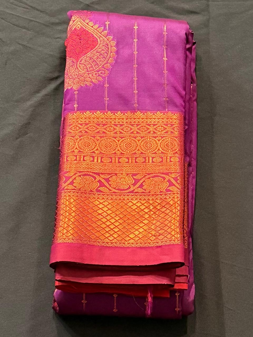 Bright magenta Kanchipuram silk saree with paisley and geometric motifs, wide gold and red woven border with circular medallions