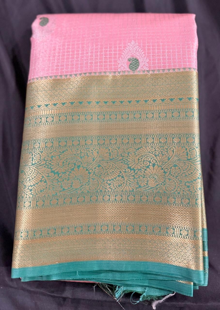 Light pink Kanchipuram silk saree with butta and geometric motifs and ornate gold border, folded detail view