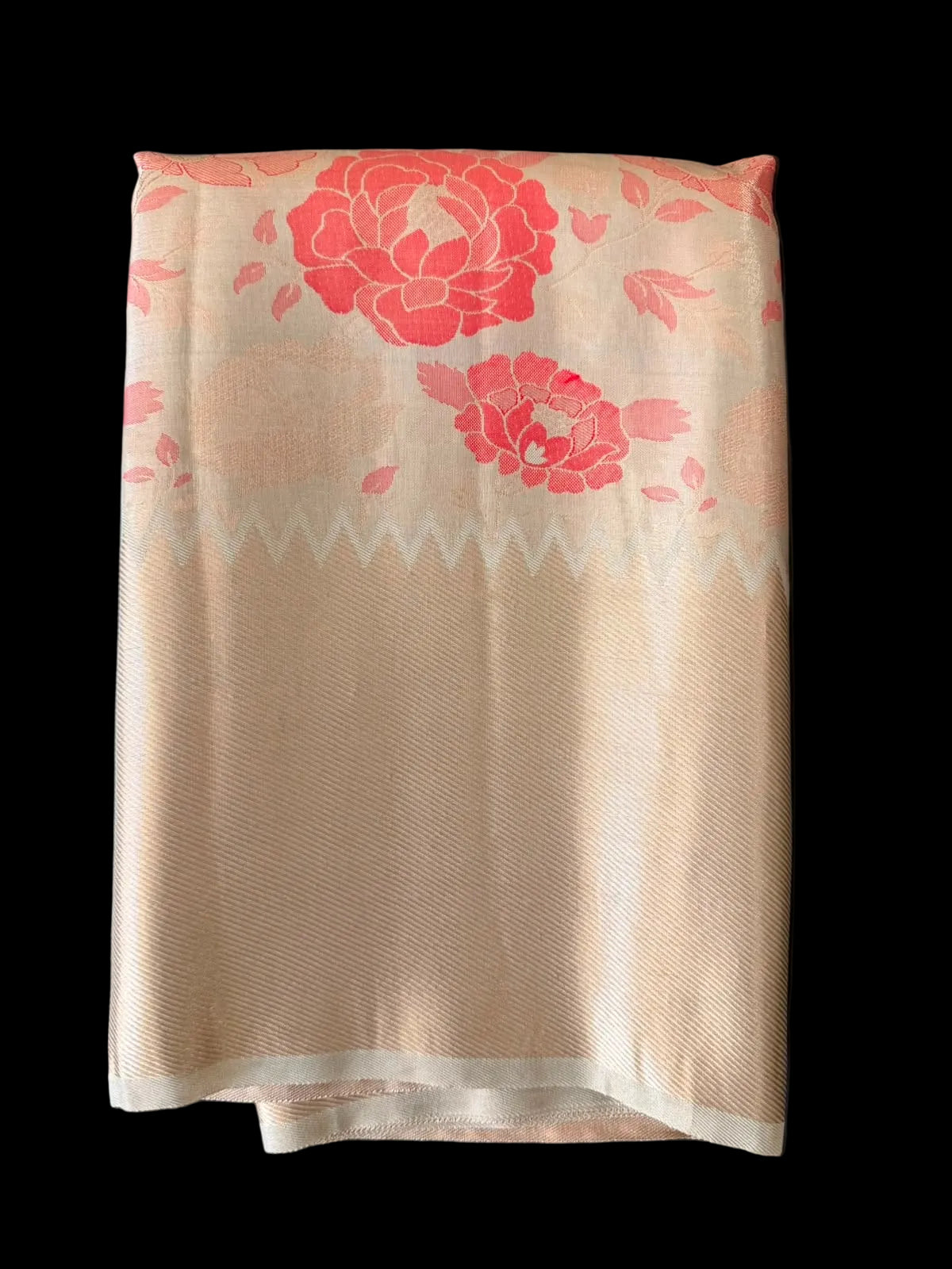 Ivory Kanchipuram silk saree with coral-red peony florals and gold-toned border, folded detail view