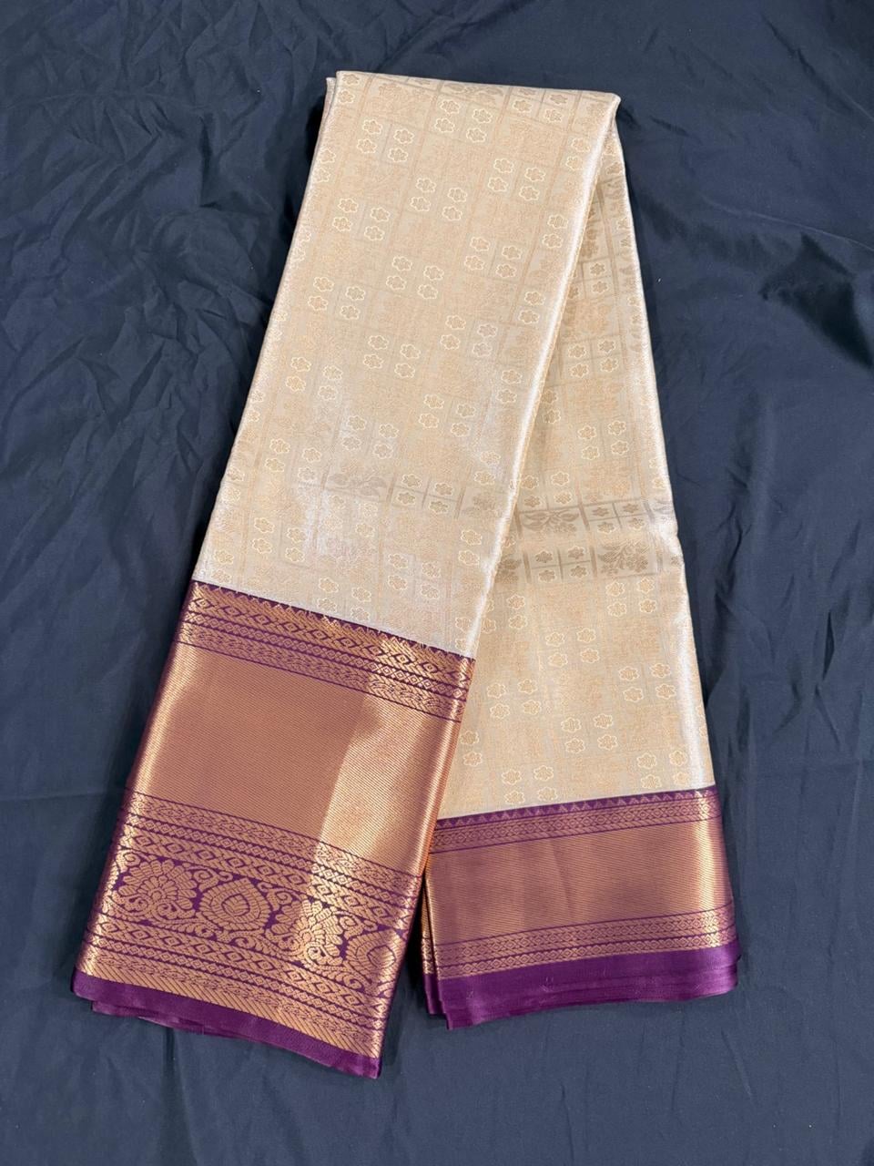 Cream Kanchipuram silk saree with butta motifs and ornate purple-gold border, detail view