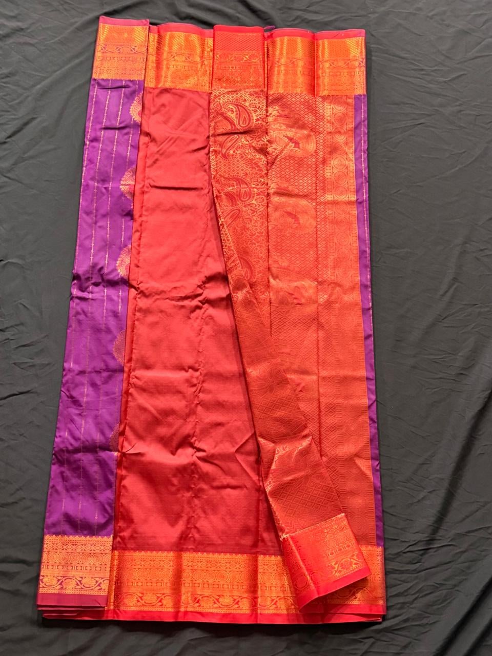 Bright magenta Kanchipuram silk saree with paisley and geometric motifs, wide gold and red woven border with circular medallions