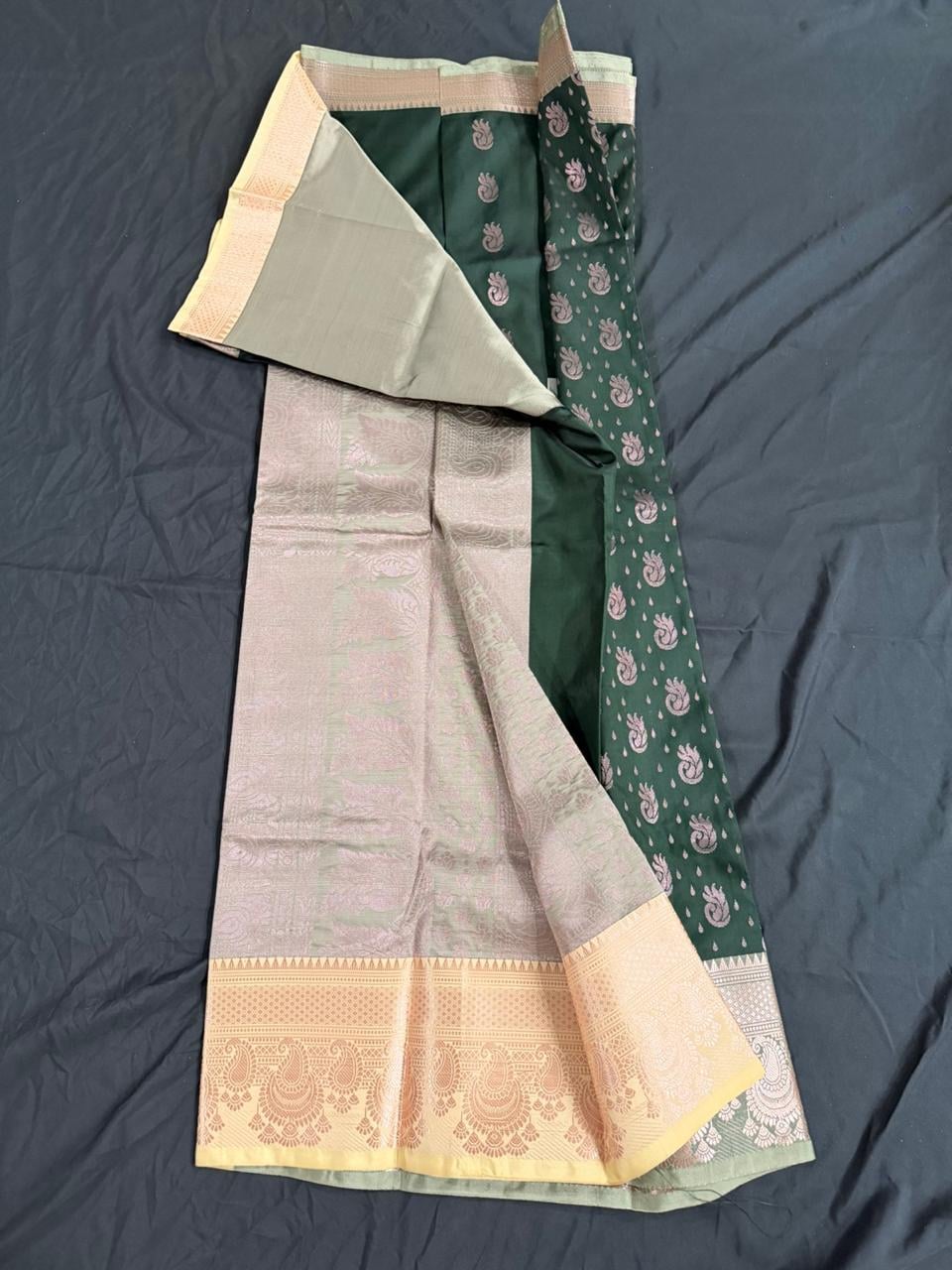Forest green saree with paisley and butta motifs and ornate gold border, draped product view
