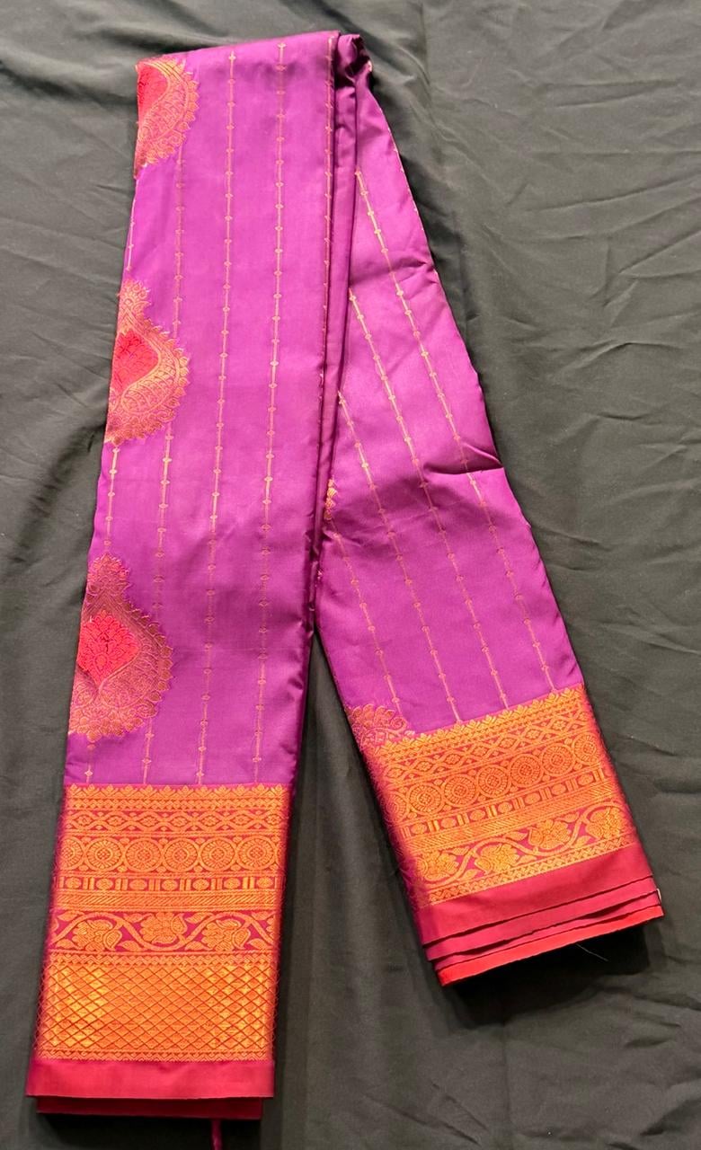 Bright magenta Kanchipuram silk saree with paisley and geometric motifs, wide gold and red woven border with circular medallions